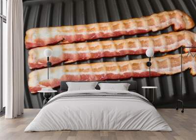 Raw slices of bacon on grill, closeup Wall mural