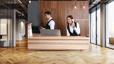 Receptionists working at desk in modern lobby Wall mural