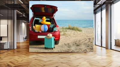 Red car luggage on beach, space for text. Summer vacation trip Wall mural