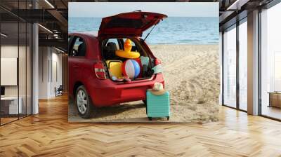 Red car luggage on beach, space for text. Summer vacation trip Wall mural