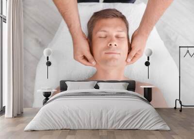 Relaxed man receiving head massage in wellness center, top view Wall mural