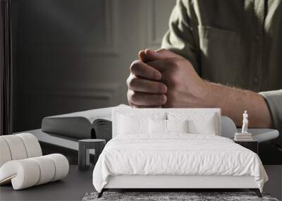 Religion. Christian man praying over Bible indoors, closeup Wall mural