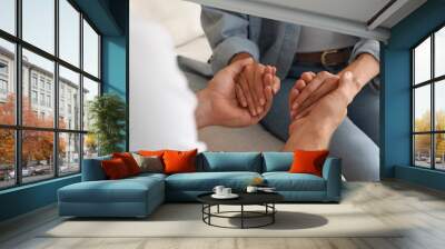 Religious people holding hands and praying together indoors, closeup Wall mural