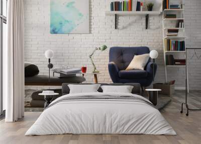 Room interior with comfortable armchair and different books near brick wall Wall mural