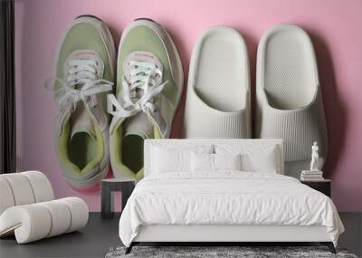 Rubber slippers and sneakers on pink background, top view Wall mural