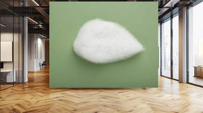 Sample of fluffy foam on green background, top view Wall mural