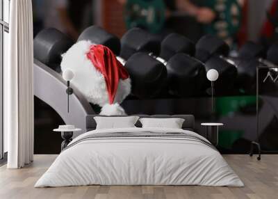 Santa Claus hat on stand with dumbbells in gym Wall mural