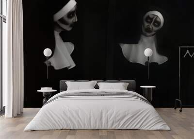 Scary devilish nun near mirror on black background. Halloween party look Wall mural