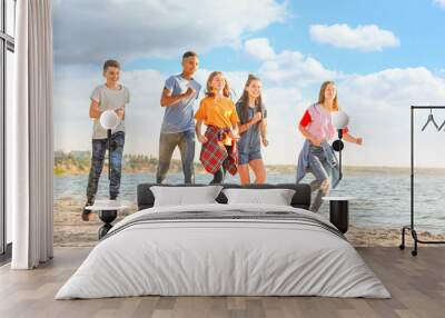 School holidays. Group of happy children running on beach Wall mural