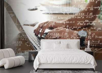 Science and education concept. Illustration of basic physics and mathematics formulas and man working on laptop at table, closeup Wall mural