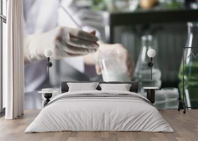 Scientist working in cosmetic laboratory, focus on jars with cream Wall mural