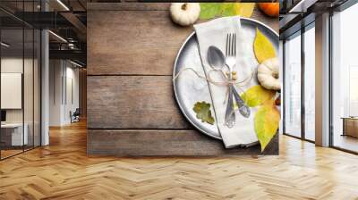 Seasonal table setting with pumpkins and other autumn decor on wooden background, flat lay. Space for text Wall mural