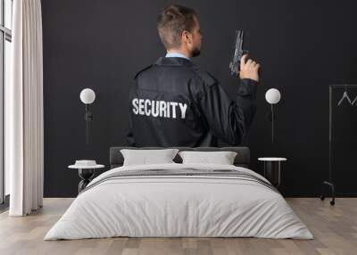 Security guard in uniform with gun on black background Wall mural