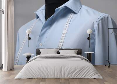 Semi-ready shirt with tailor's measuring tape on mannequin against grey background, closeup Wall mural