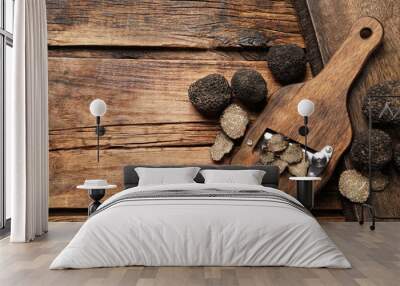 Shaver with whole and sliced black truffles on wooden table, flat lay. Space for text Wall mural