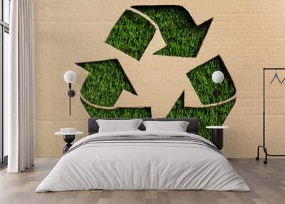 Sheet of cardboard with cutout recycling symbol on green grass, top view Wall mural