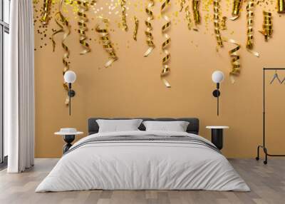 Shiny golden serpentine streamers and confetti on beige background, flat lay. Space for text Wall mural