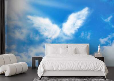 Silhouette of angel's wings made of clouds in blue sky Wall mural