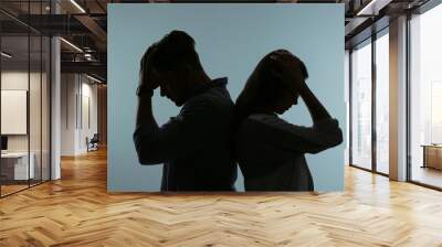 Silhouette of upset couple on color background. Relationship problems Wall mural