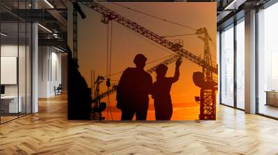 Silhouettes of engineers near construction site at sunrise Wall mural