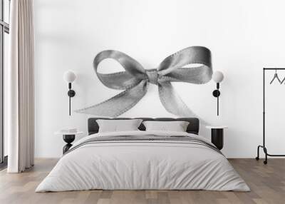 Silver satin ribbon tied in bow on white background, top view Wall mural