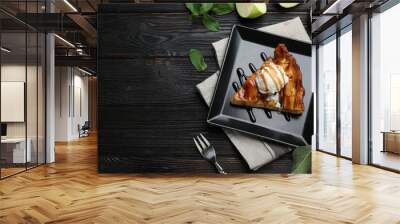 Slice of traditional apple pie with ice cream served on black wooden table, flat lay. Space for text Wall mural