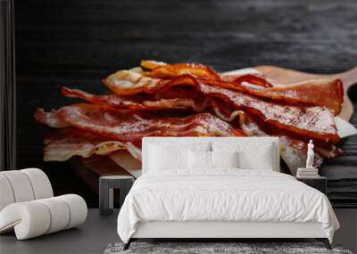 Slices of tasty fried bacon on black wooden table, closeup Wall mural