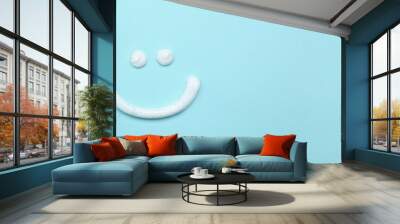 Smiling face made of toothpaste, brush and tube on light blue background, flat lay with space for text. Banner design Wall mural