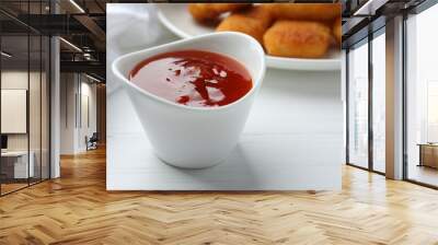 Spicy chili sauce in bowl on white wooden table, closeup Wall mural