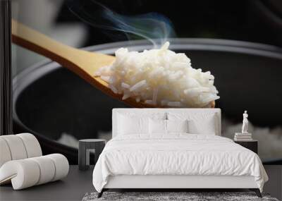 Spoon with tasty hot rice over cooker, closeup Wall mural