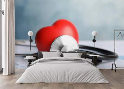 Stethoscope, red heart and cardiogram on table. Cardiology concept Wall mural