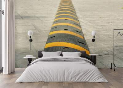 Striped plastic speed bump on pavement outdoors, closeup Wall mural