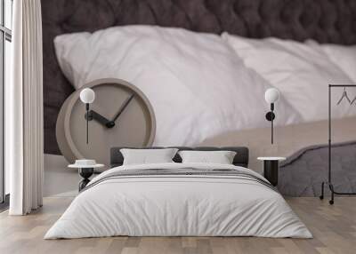 Stylish alarm clock on nightstand in bedroom. Space for text Wall mural