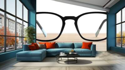 Stylish glasses with black frame on wooden table against white background Wall mural