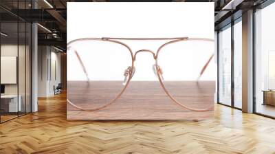 Stylish glasses with metal frame on wooden table against white background Wall mural