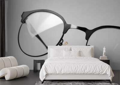 Stylish pair of glasses with black frame on beige background, closeup Wall mural