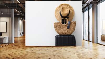 Suitcase and summer accessories on light background. Space for text Wall mural