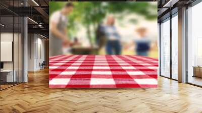 Table with checkered picnic cloth outdoors on sunny day. Space for design Wall mural