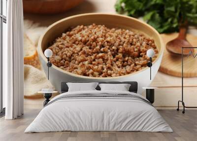 Tasty buckwheat in bowl on wooden table, closeup Wall mural