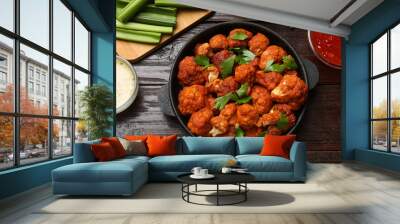 Tasty cauliflower buffalo wings, sauces and celery on wooden table, flat lay Wall mural