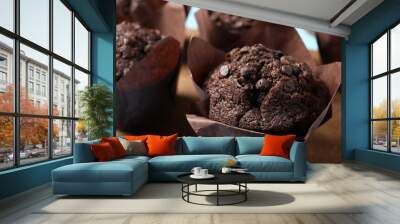 Tasty chocolate muffins on wooden board, closeup Wall mural