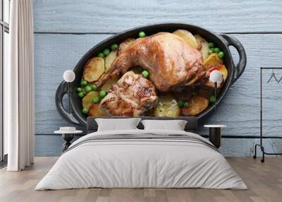 Tasty cooked rabbit with vegetables in baking dish on grey wooden table, top view Wall mural