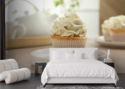 Tasty cupcake with vanilla cream on light wooden table, closeup Wall mural