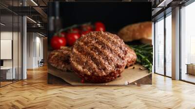 Tasty grilled hamburger patties with seasonings on wooden table, closeup Wall mural