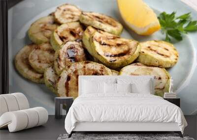 Tasty grilled zucchini slices with lemon and parsley on table, closeup Wall mural