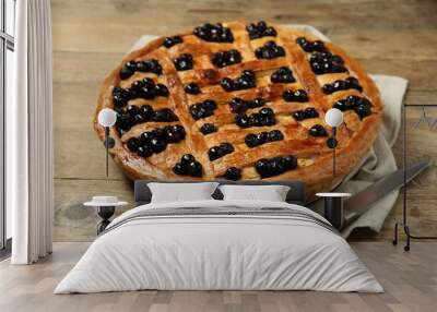 Tasty homemade pie with blueberries and knife on wooden table Wall mural