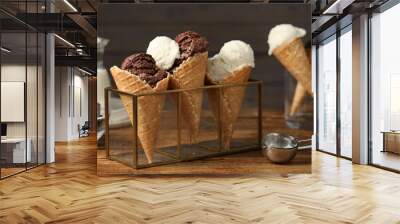 Tasty ice cream scoops in waffle cones on wooden table, closeup Wall mural