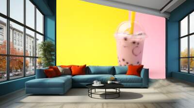 Tasty milk bubble tea in plastic cup on color background, space for text Wall mural