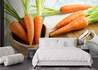 Tasty ripe juicy carrots in bowl on white marble table, closeup Wall mural