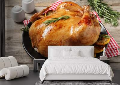 Tasty roasted chicken with rosemary and lemon on wooden table Wall mural